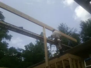 Carpenter setting a ridge beam over a new addition frame — Ice Dam Removal by Roofing Brothers in Hershey