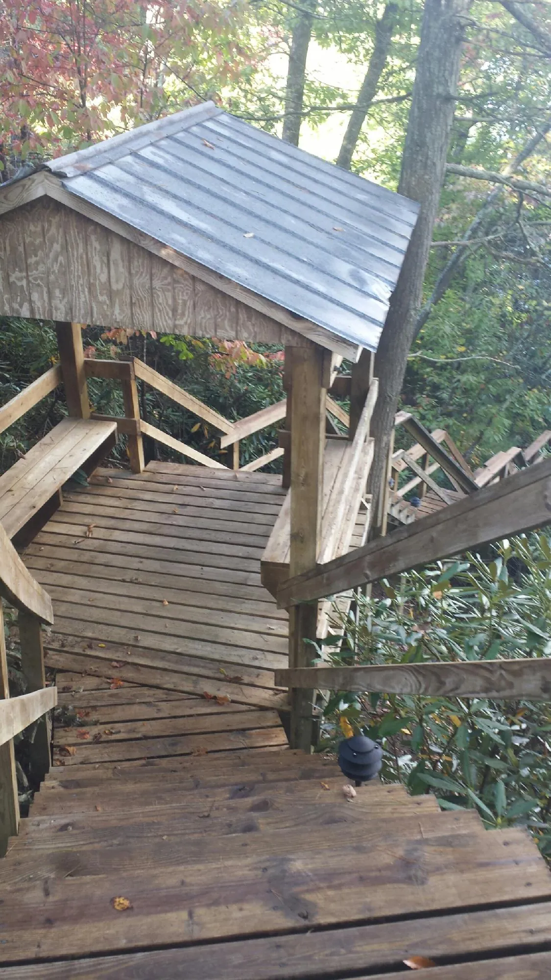 Metal roofed shelter over wooden steps on a wooded walkway — Skylight Repair & Installation work by our crew in Hershey