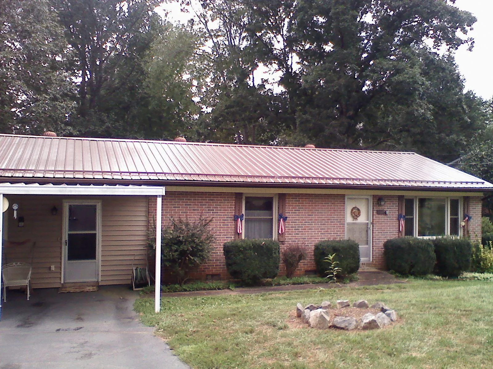 Bronze metal roof and carport on a brick ranch home — Roof Repair work by our crew in Hershey